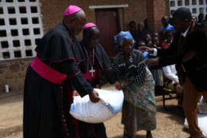 Bishop Msusa & Mtumbuka handing over a bag of maize to a flood victim