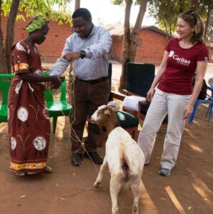 ECM Secretary General (C) hands over a goat to a farmers (L) as Jamie (R) looks on-Picture by Prince Henderson