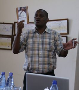 Rev. Fr. Dr Kazingatchire showing the Seminarians at ICS  an Encyclical book