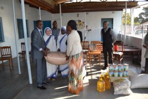 Hon. Kasaila (R) and Hon Lunguzi (L) helping each other to hand over a bag of maize to the sisters